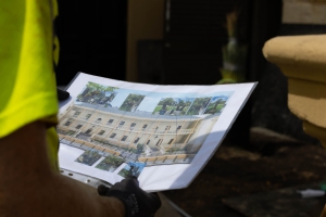 a person is holding a piece of paper with a picture of a building